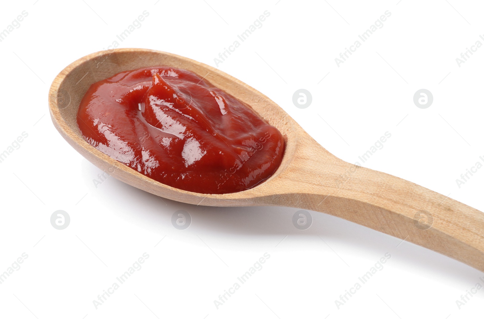 Photo of Ketchup in wooden spoon isolated on white, closeup