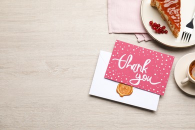 Photo of Card with phrase Thank You, cheesecake and coffee on light wooden table, flat lay. Space for text