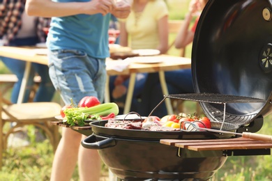 Photo of Modern grill with food and blurred people on background