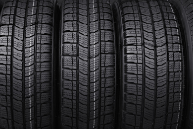 Photo of Car tires as background, closeup. Auto store