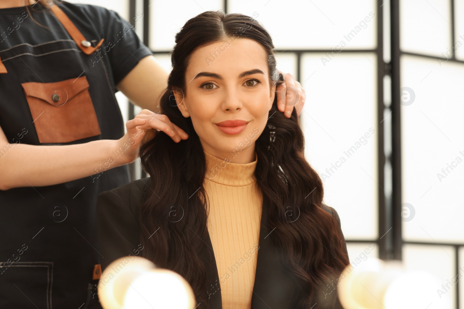 Photo of Hair styling. Professional hairdresser working with client indoors, closeup