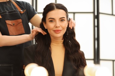 Hair styling. Professional hairdresser working with client indoors, closeup