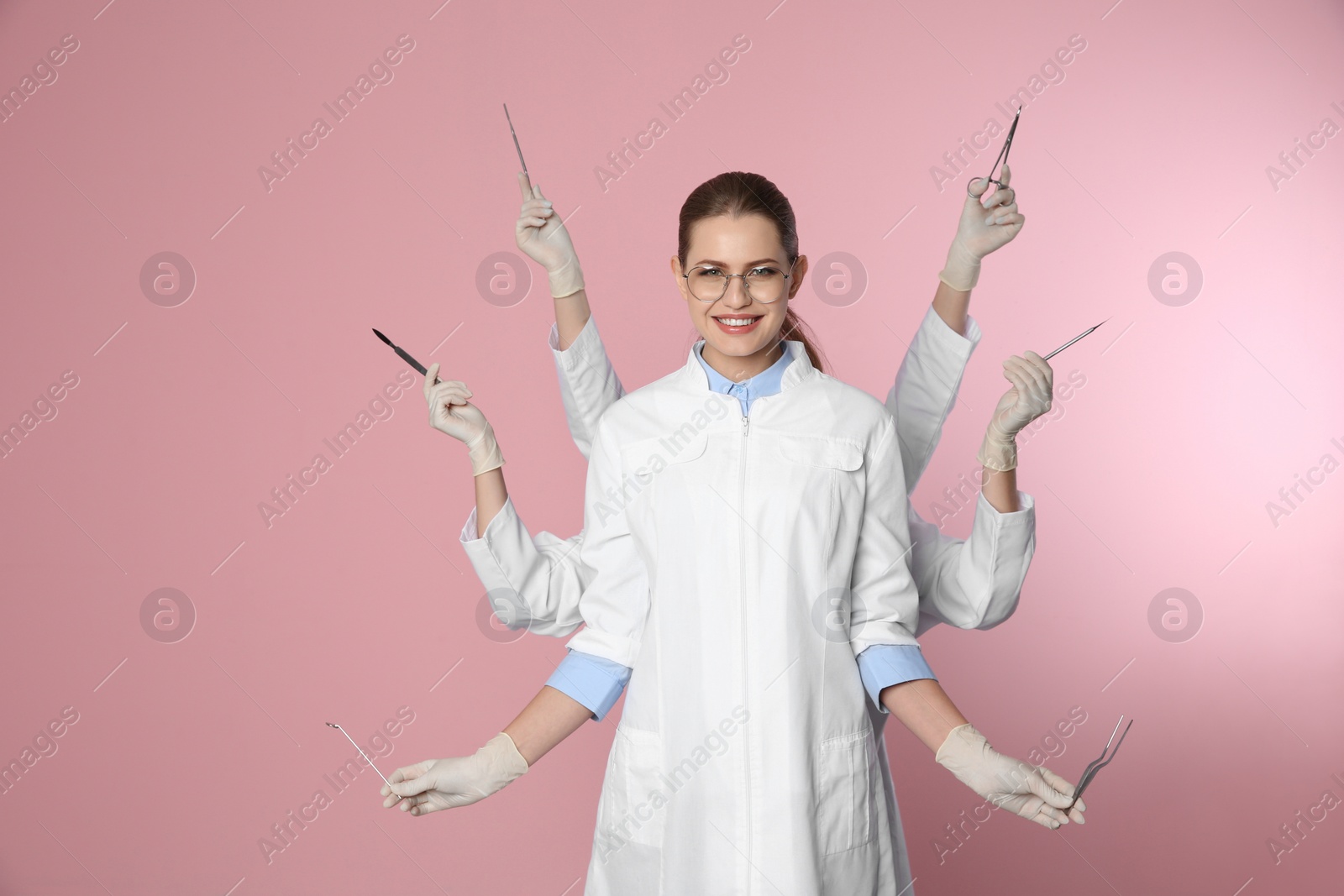 Photo of Female dentist with multiple hands holding tools on color background
