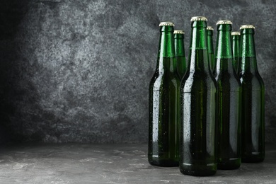 Bottles of beer on grey table. Space for text