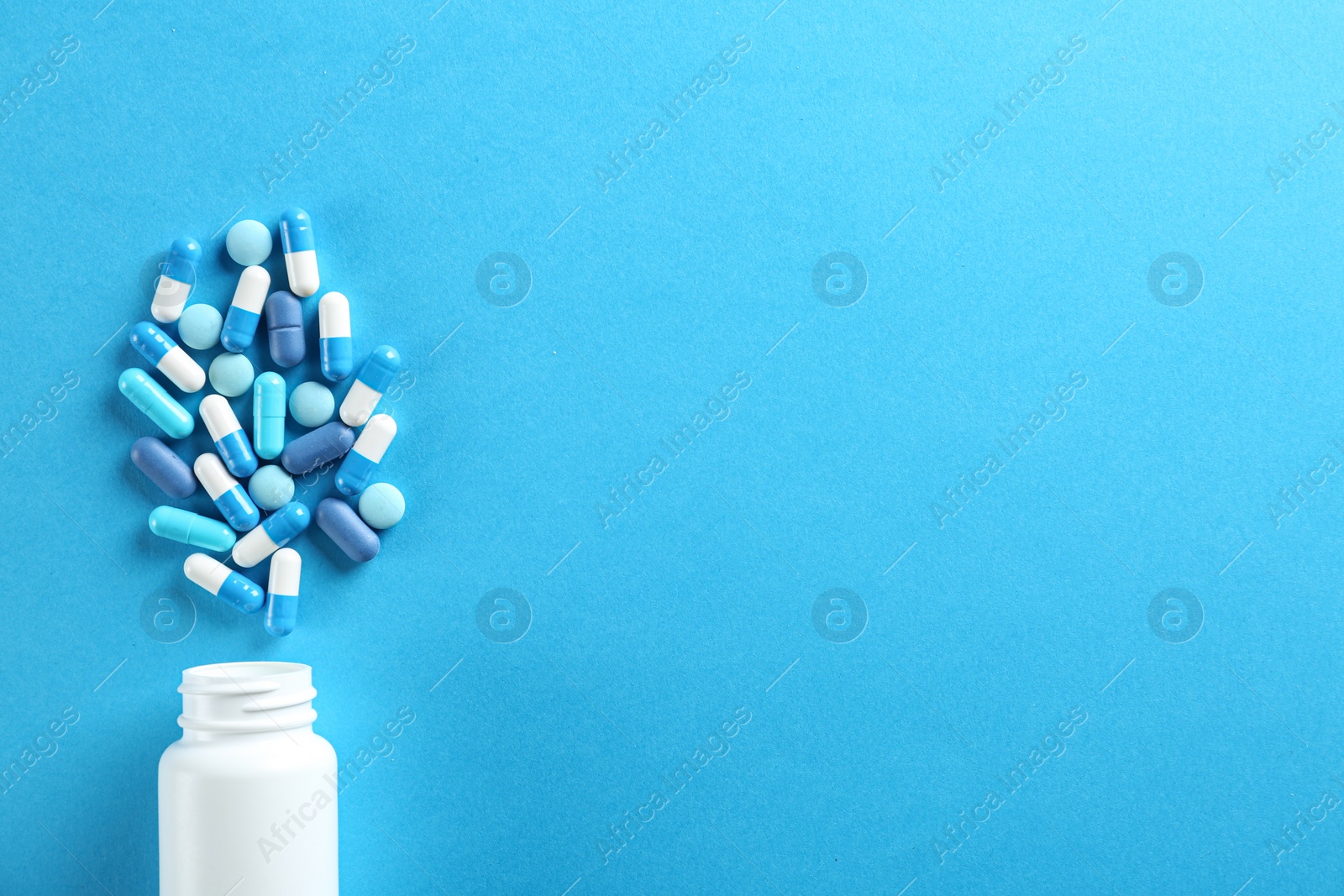 Photo of Flat lay composition with pills on light blue background. Space for text