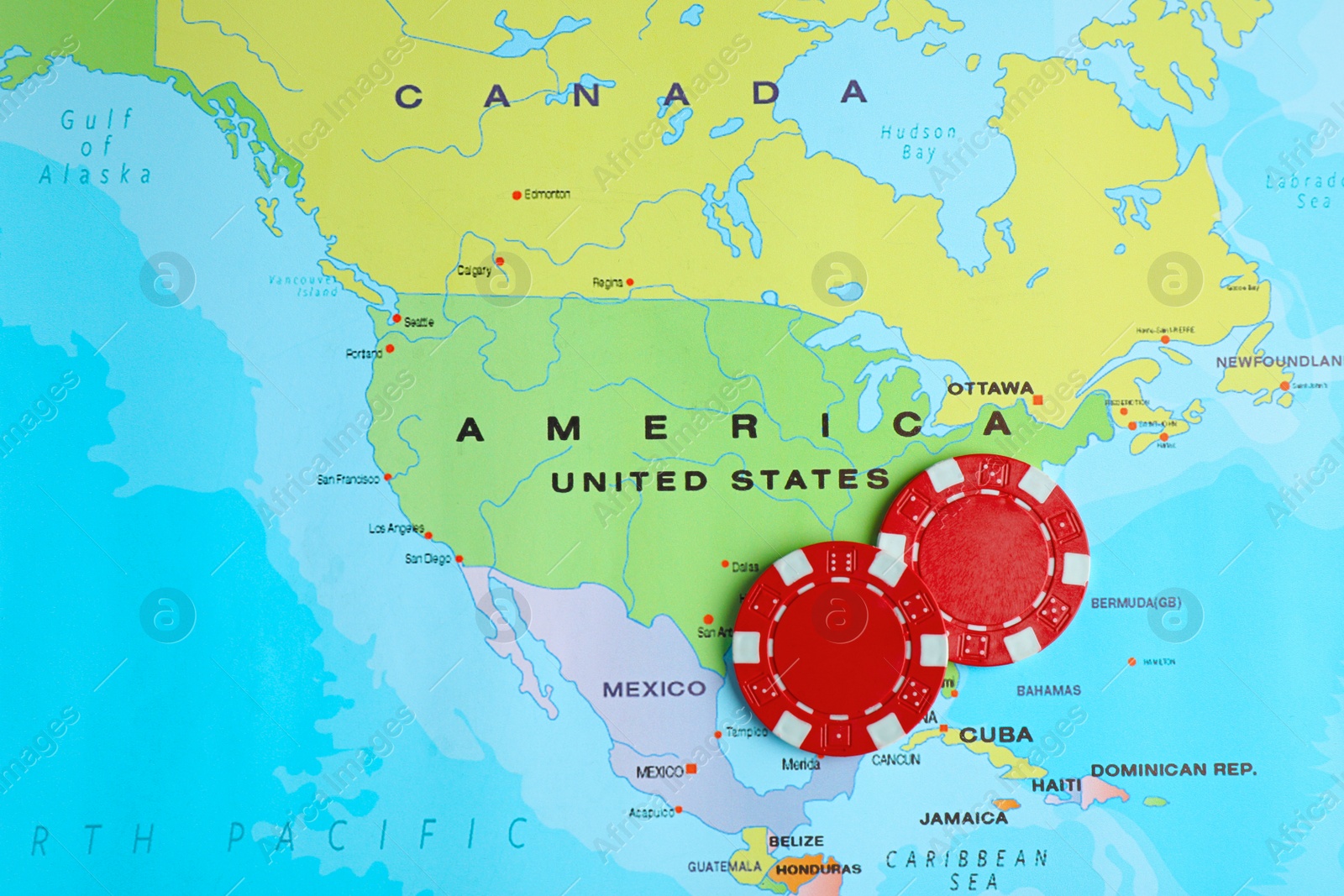 Photo of Red casino chips near USA on world map, top view