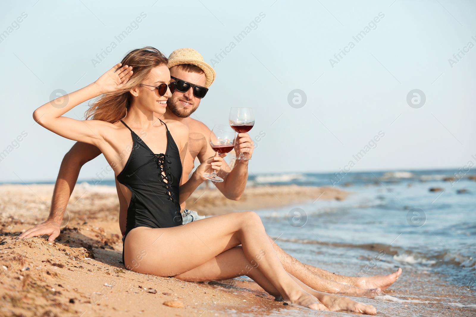 Photo of Young couple with glasses of wine on beach