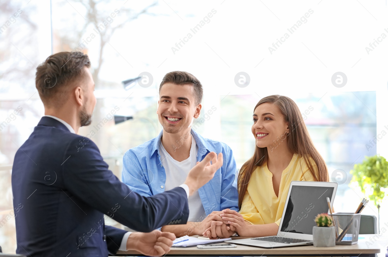 Photo of Young couple meeting with consultant in office