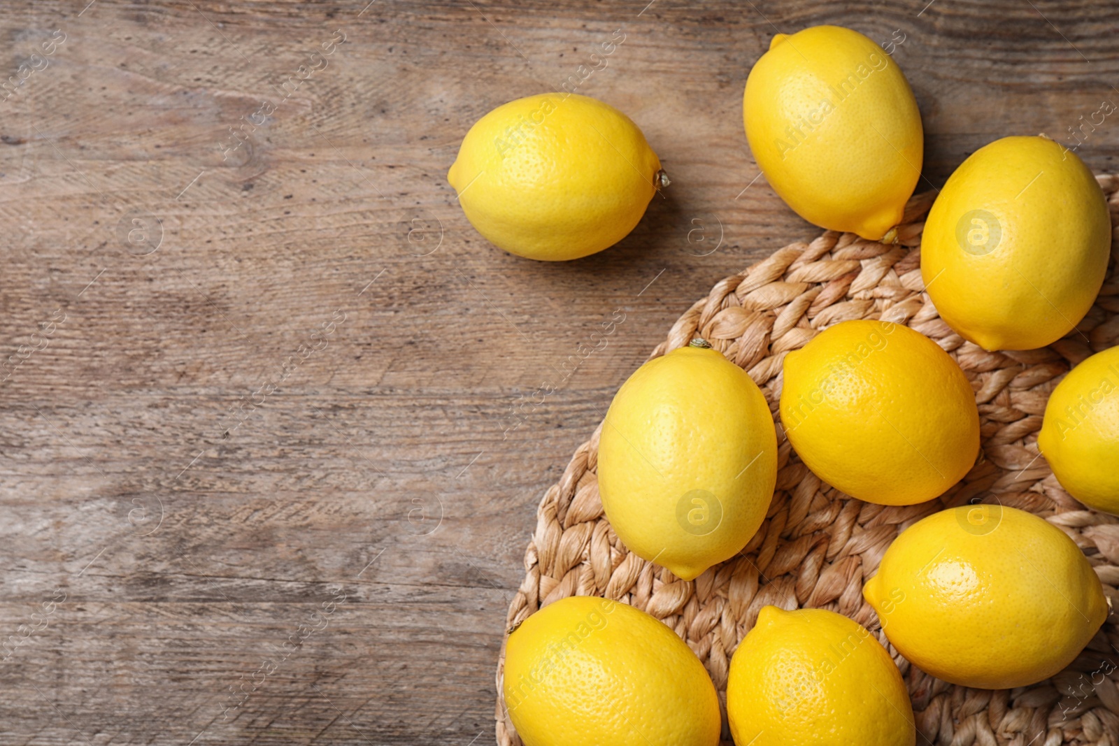 Photo of Fresh lemons on wooden table, flat lay. Space for text