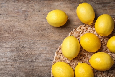 Fresh lemons on wooden table, flat lay. Space for text