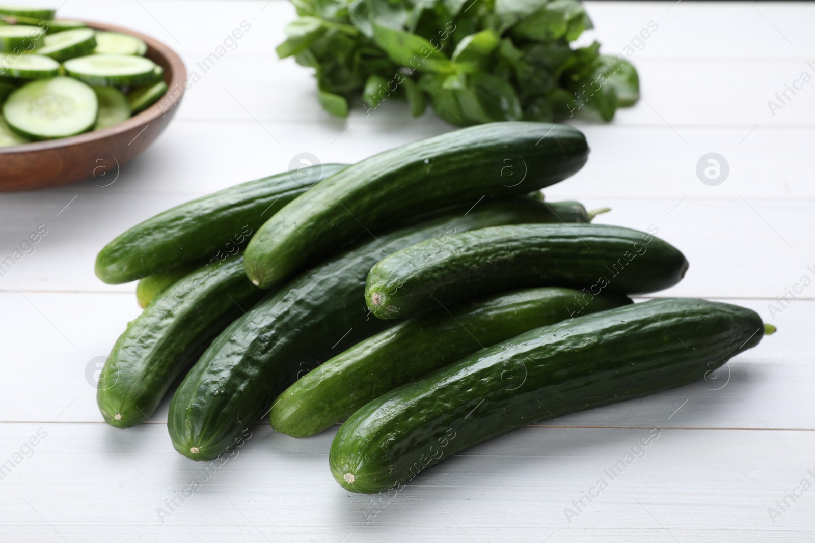 Photo of Fresh ripe cucumbers on white wooden table