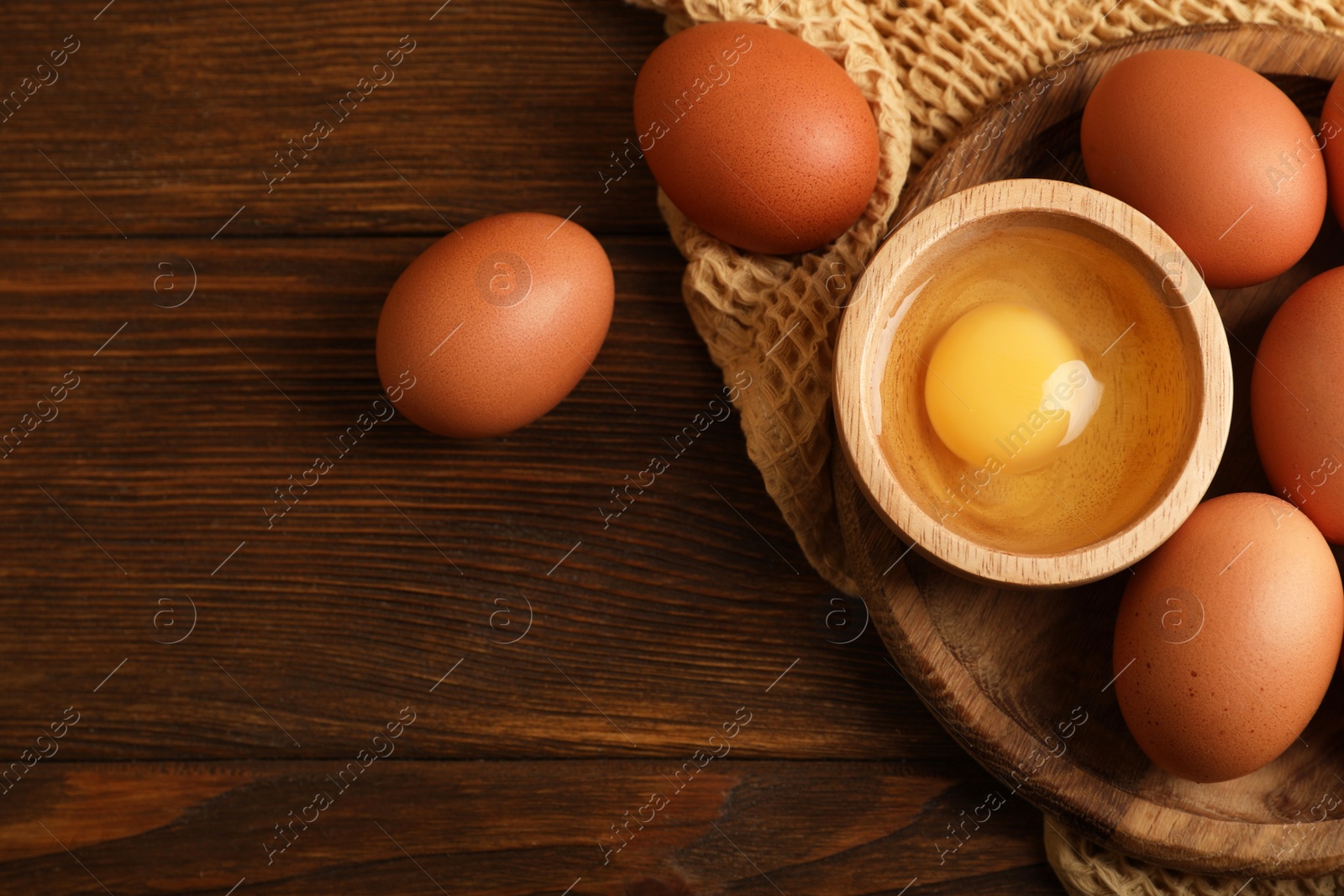 Photo of Raw chicken eggs on wooden table, flat lay. Space for text