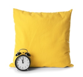 Soft decorative pillow and alarm clock on white background