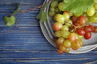 Photo of Fresh ripe juicy grapes and space for text on wooden background, top view