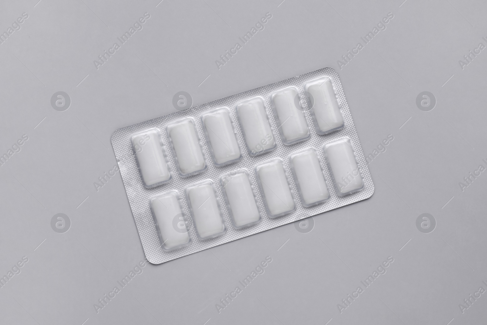 Photo of Blister with chewing gums on grey background, top view