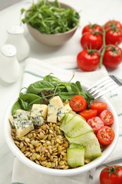 Photo of Delicious lentil bowl with blue cheese, tomatoes and cucumber on white table