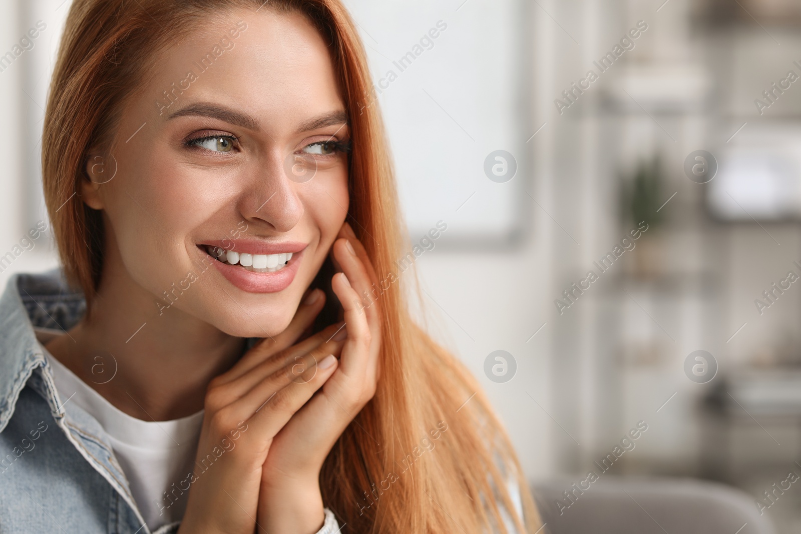 Photo of Portrait of beautiful smiling young woman. Happy lady with red hair at home. Space for text