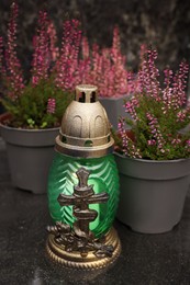 Photo of Grave lantern on black tiled surface at cemetery