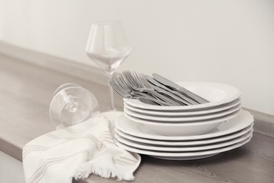 Set of clean dishware, cutlery and wineglasses on table indoors