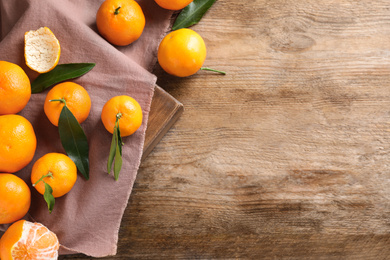 Photo of Fresh ripe tangerines on wooden table, flat lay. Space for text