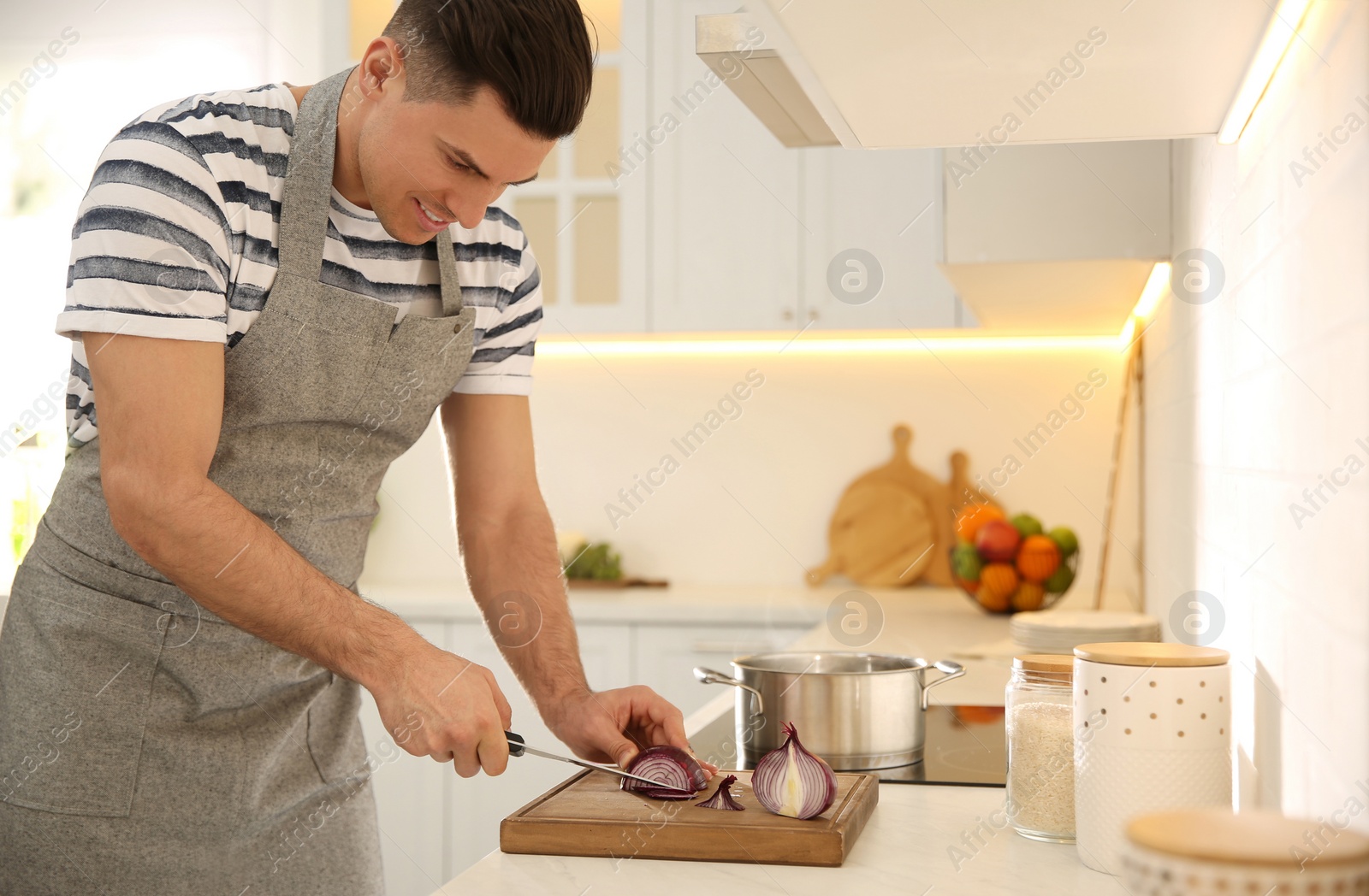 Photo of Handsome man cooking at counter in kitchen