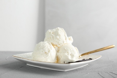 Plate with tasty vanilla ice cream on table