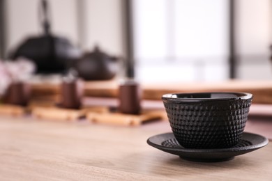 Photo of Cup with saucer for traditional tea ceremony on wooden table