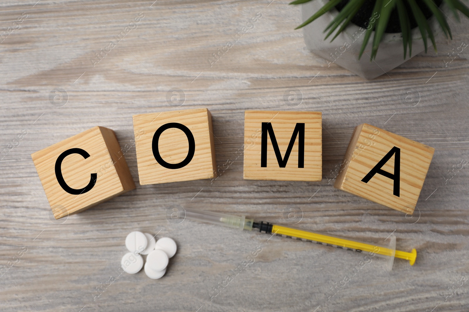 Photo of Cubes with word Coma, syringe and pills on wooden table, flat lay