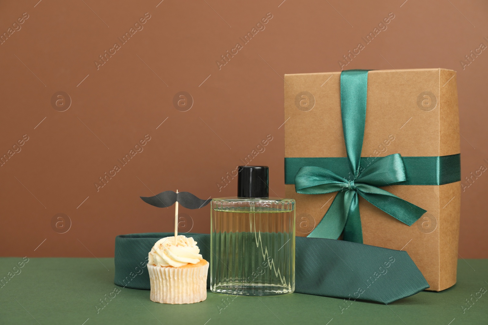 Photo of Happy Father's Day. Tasty cupcake with topper and presents on green table. Space for text