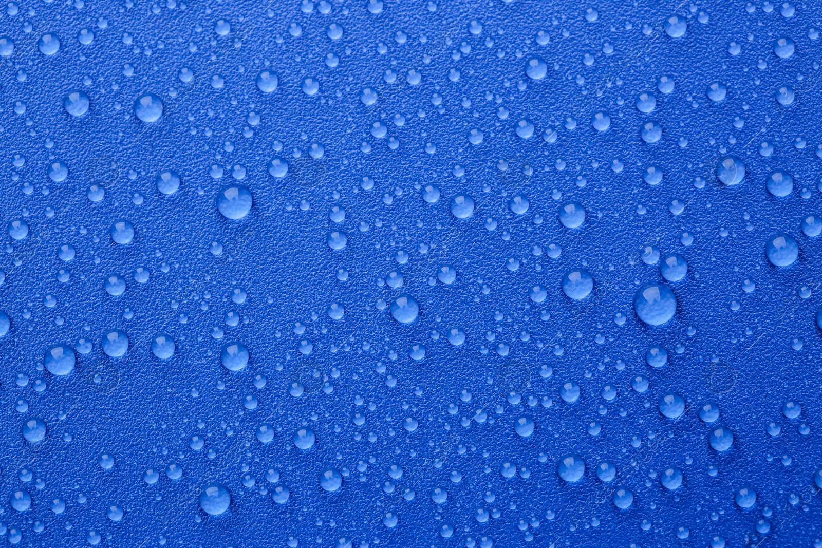 Photo of Water drops on blue background, top view