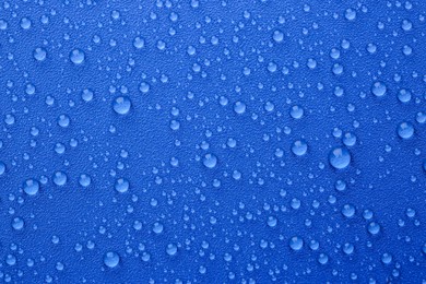 Water drops on blue background, top view