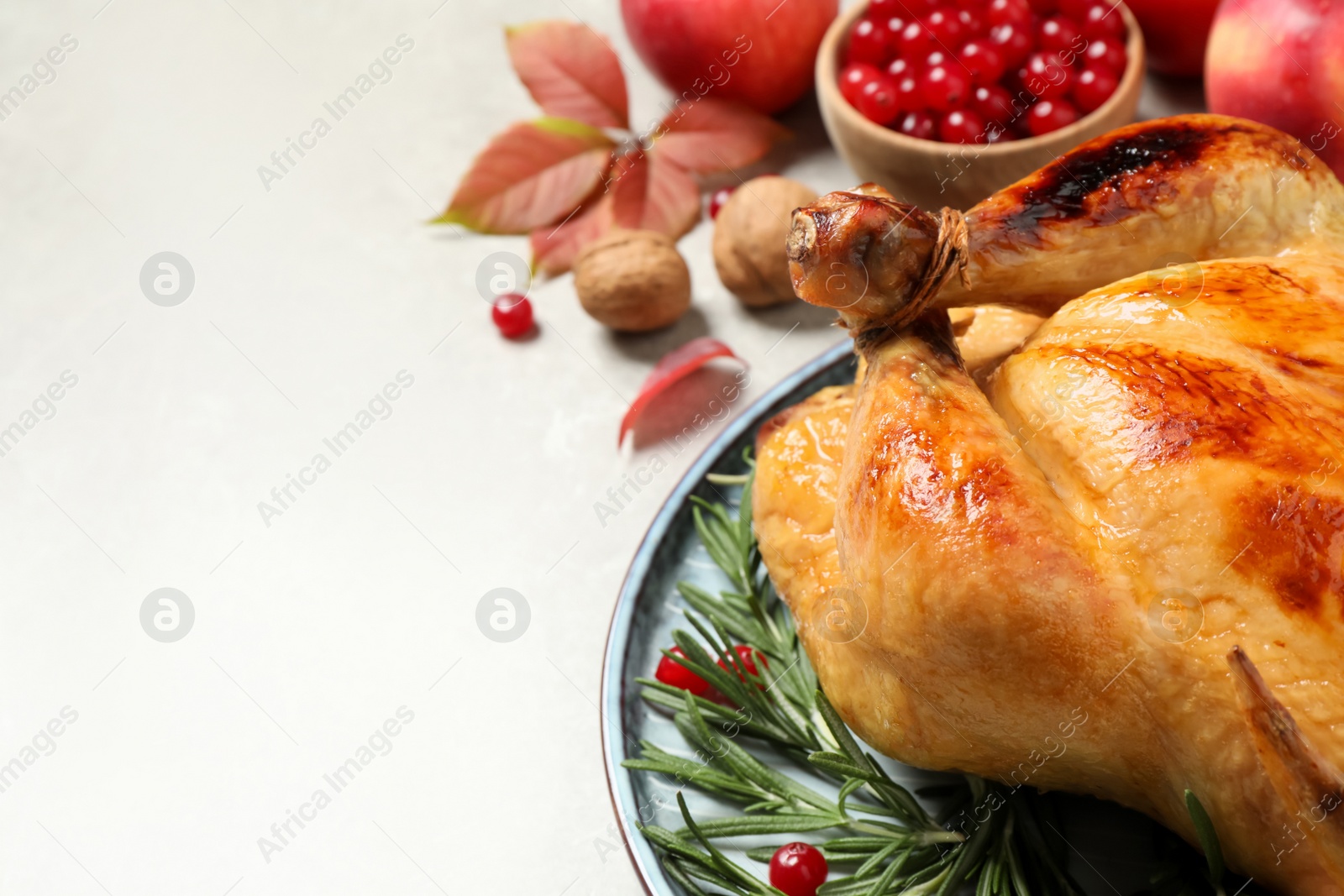 Photo of Traditional Thanksgiving day feast with delicious cooked turkey and autumn decor on grey table, closeup. Space for text