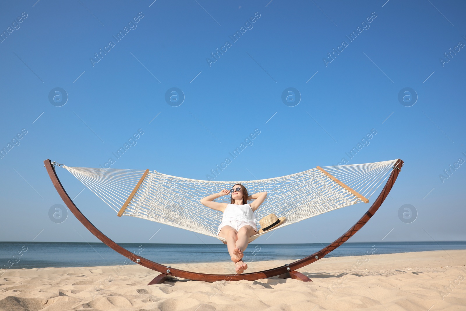 Photo of Young woman relaxing in hammock on beach