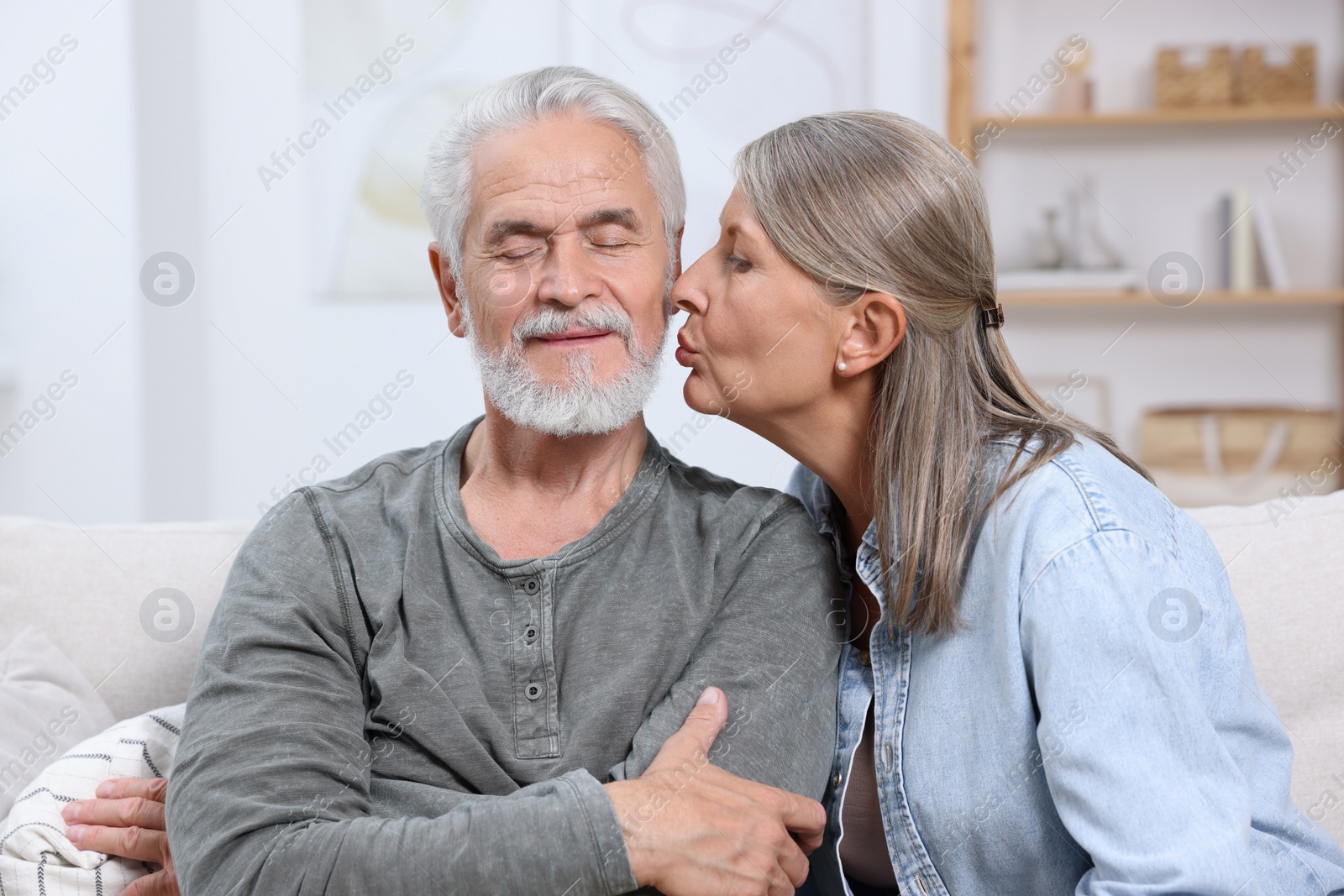 Photo of Senior woman kissing her beloved man at home