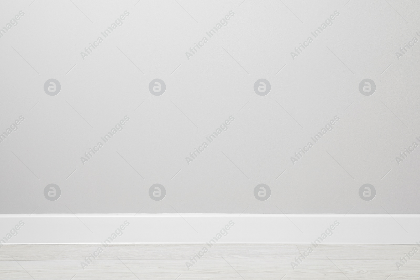 Photo of White plinth on laminated floor near wall indoors