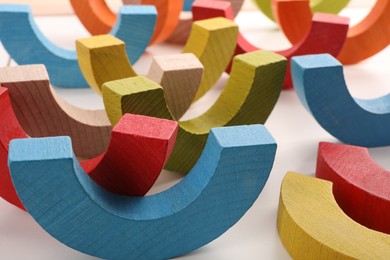 Photo of Colorful wooden pieces of playing set on white table, closeup. Educational toy for motor skills development