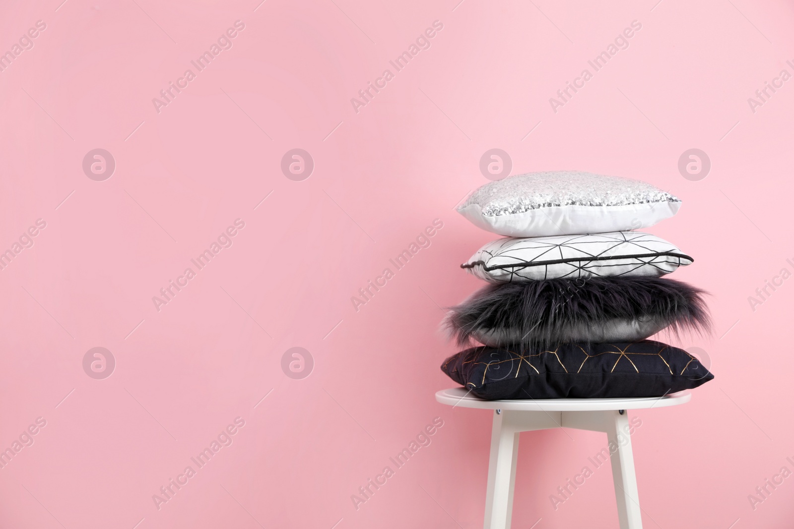 Photo of Chair with many different pillows and space for text on color background