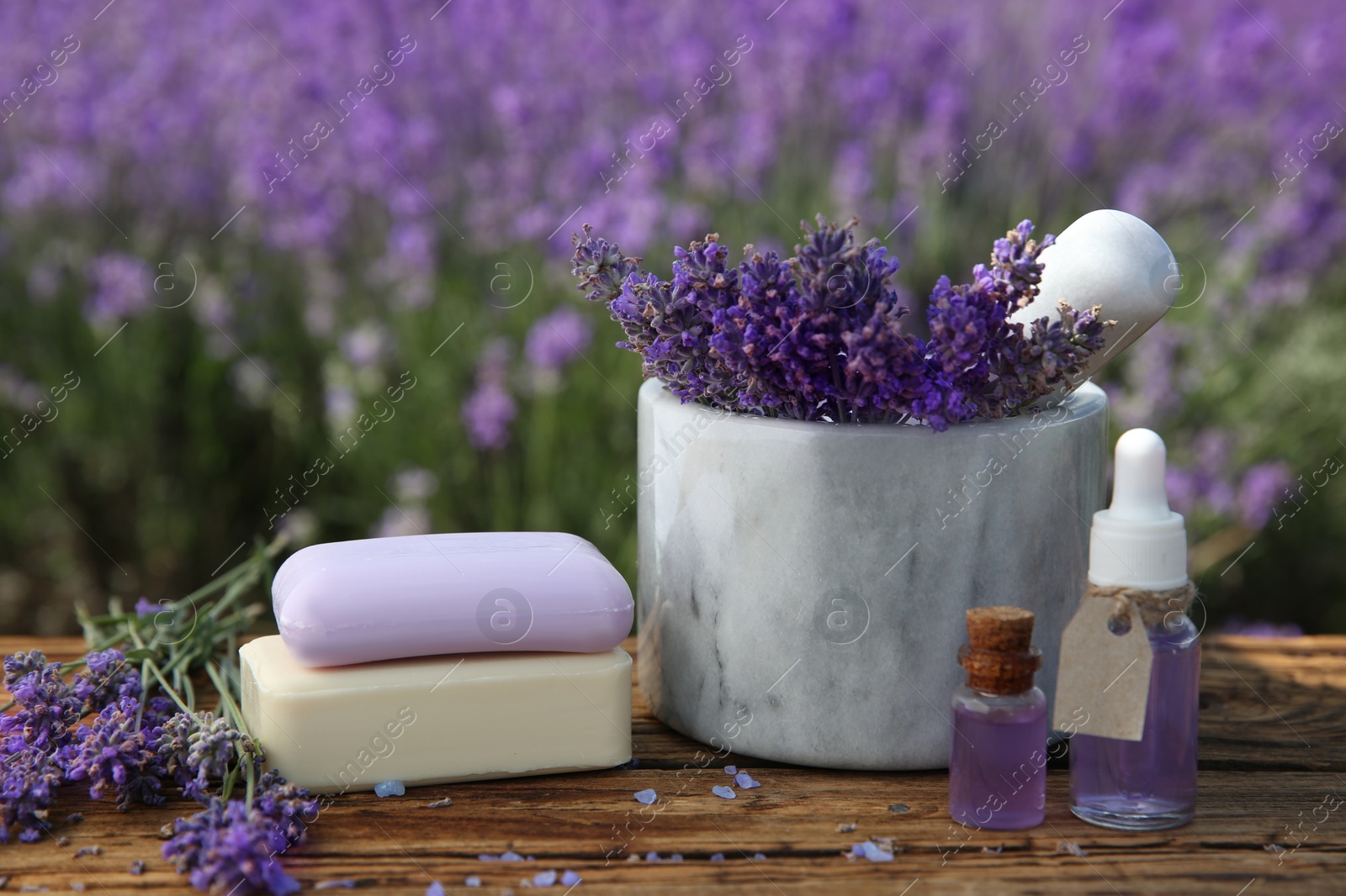 Photo of Composition with fresh lavender flowers and cosmetic products on wooden table outdoors