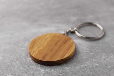 Photo of Wooden keychain in shape of smiley face on grey background, closeup