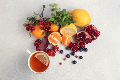 Photo of Flat lay composition with cup of delicious immunity boosting tea and ingredients on light grey table