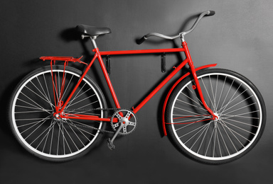 Photo of Red bicycle hanging on black wall indoors