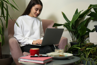 Photo of Young blogger working with laptop in office