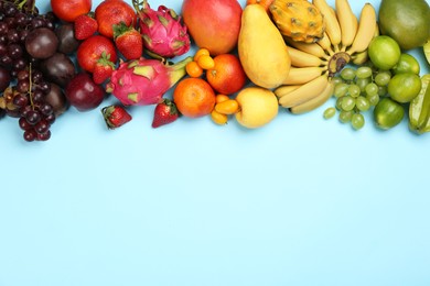 Photo of Many different delicious exotic fruits on light blue background, flat lay. Space for text