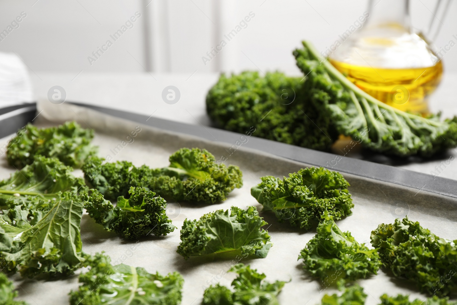 Photo of Raw cabbage leaves on baking sheet, closeup. Preparing kale chips