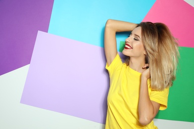 Photo of Beautiful young woman with healthy long blonde hair on color background. Space for text