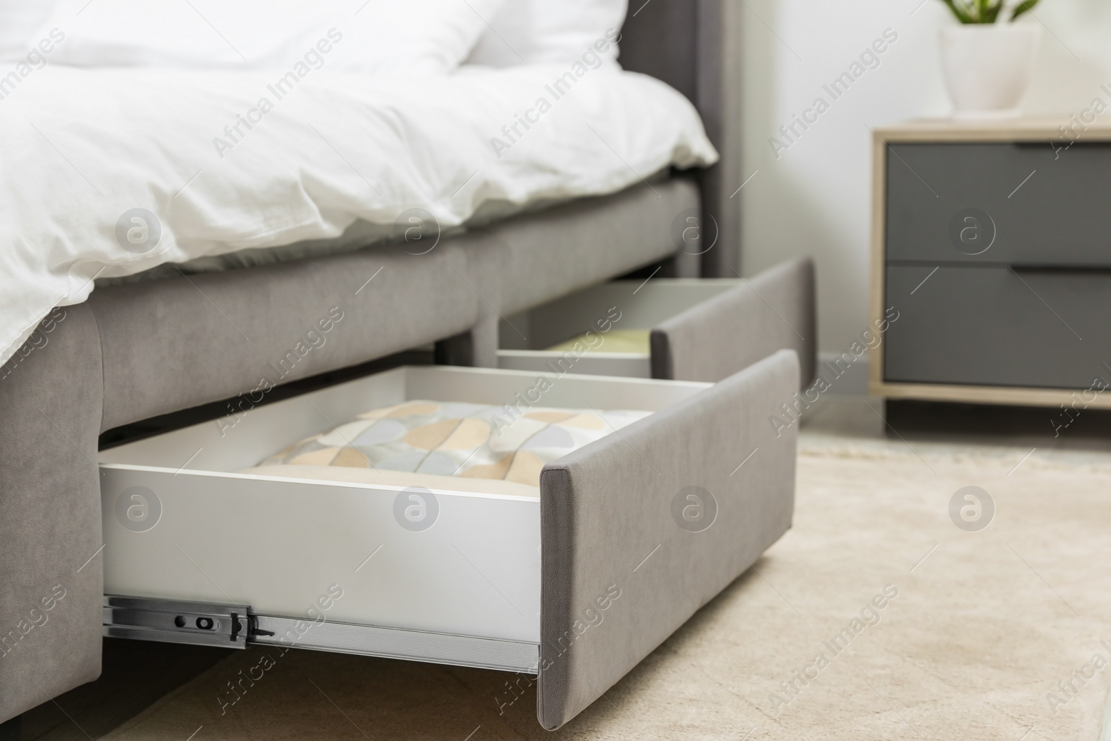 Photo of Storage drawers with bedding under modern bed in room