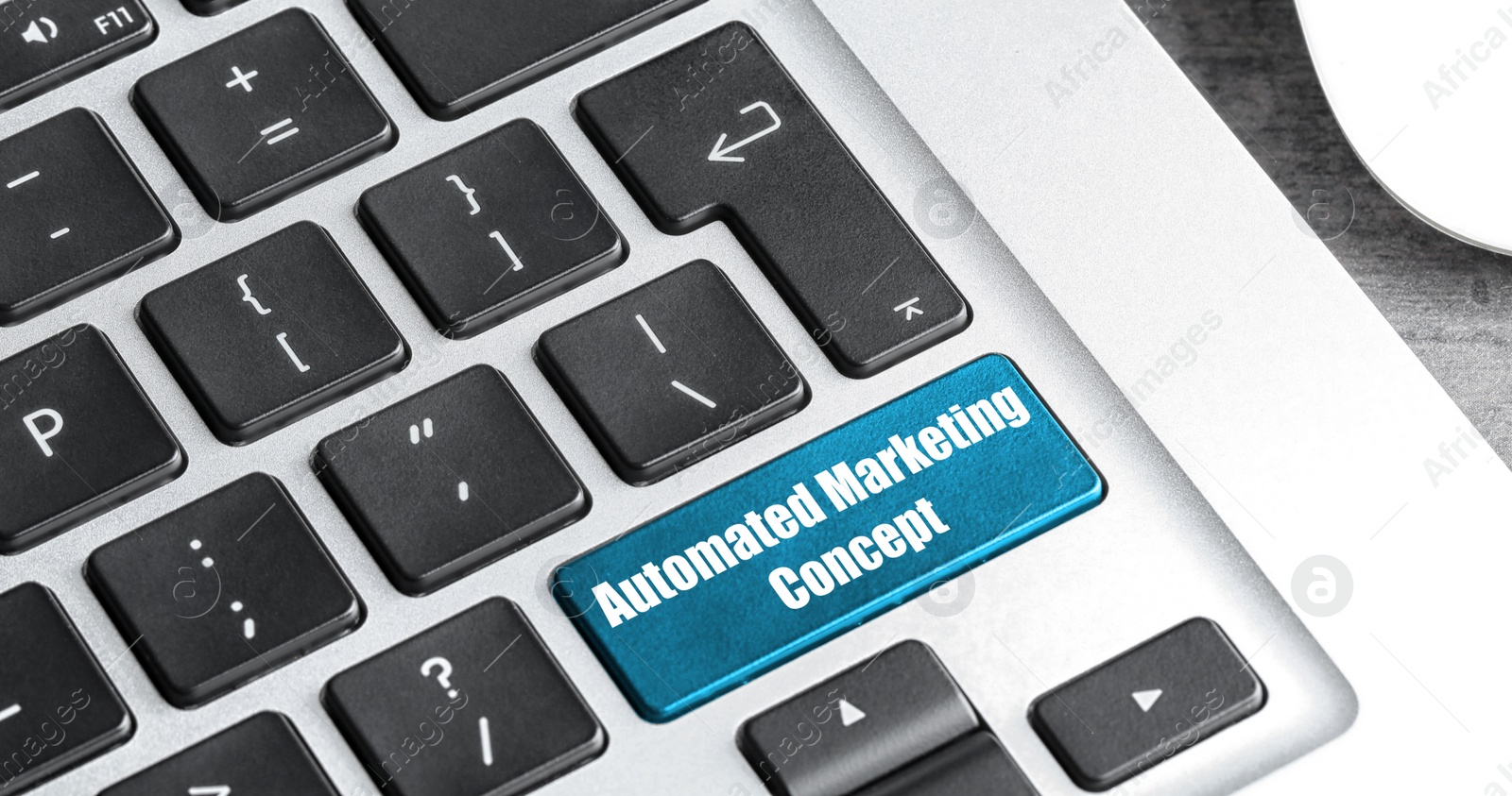 Image of Modern laptop keyboard with text AUTOMATED MARKETING CONCEPT on button, closeup. Banner design