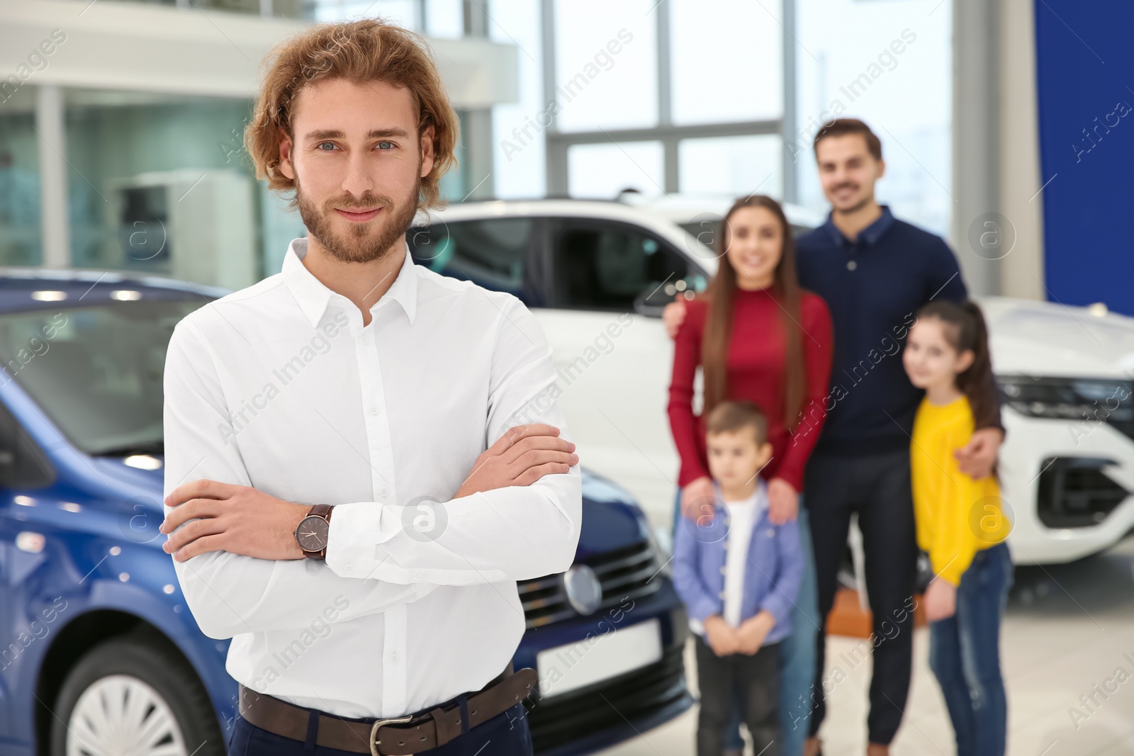 Photo of Car salesman and blurred family near auto on background