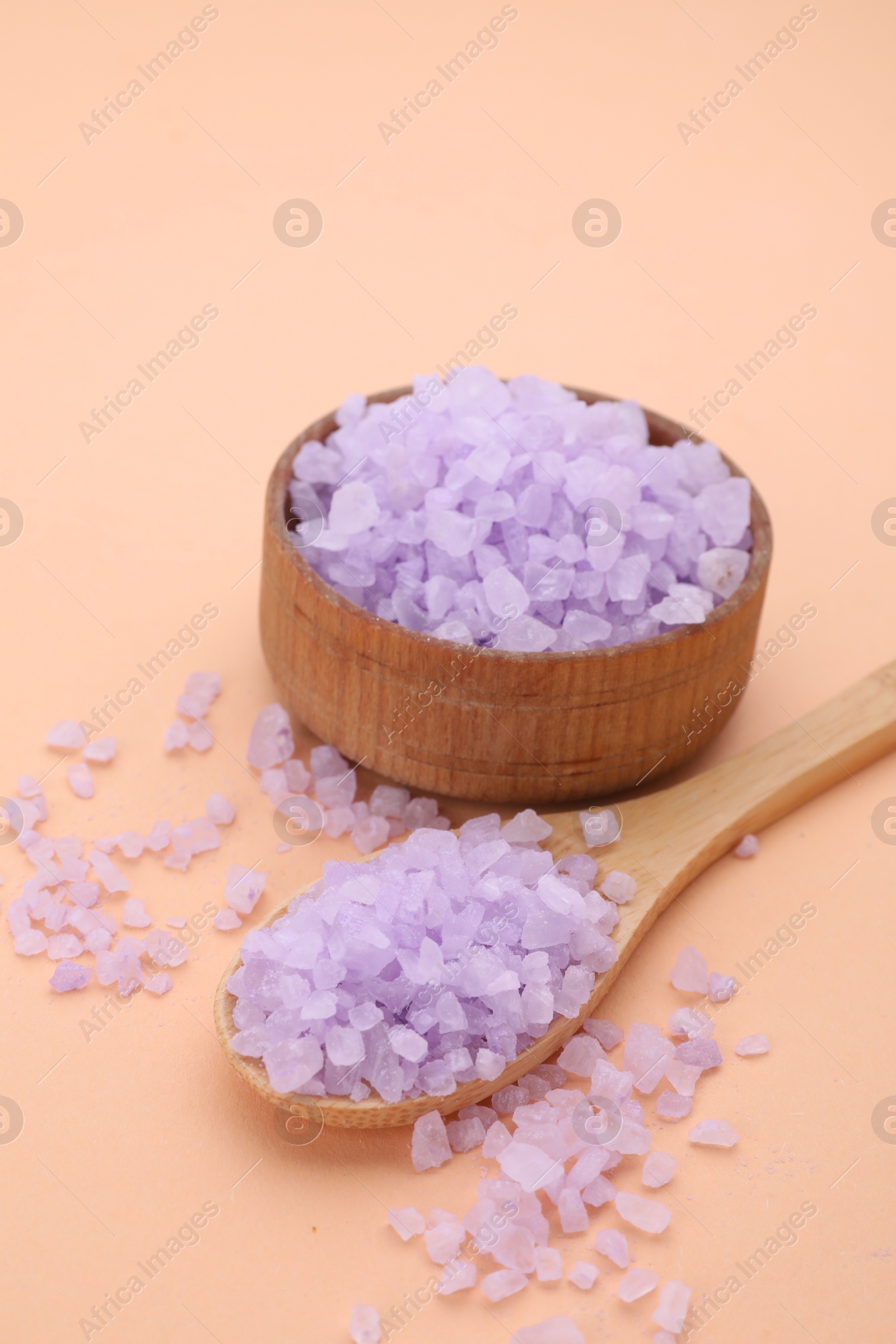 Photo of Bowl and spoon with violet sea salt on beige background