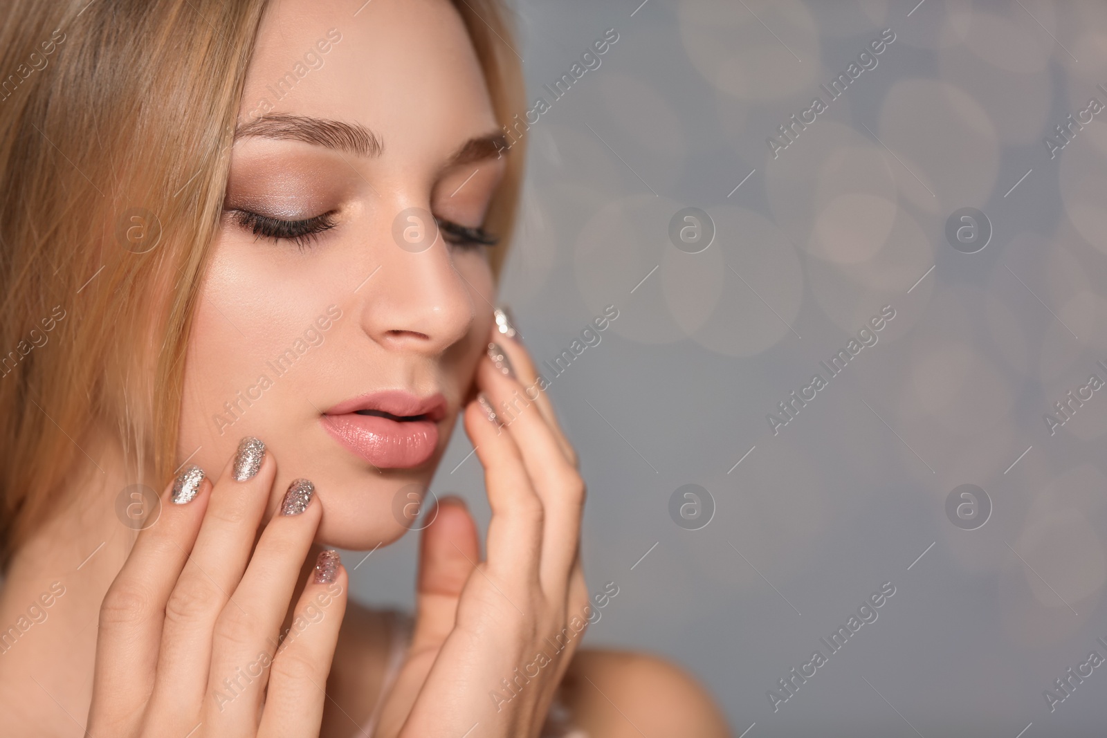 Photo of Closeup view of beautiful young woman with shiny manicure on blurred background, space for text. Nail polish trends